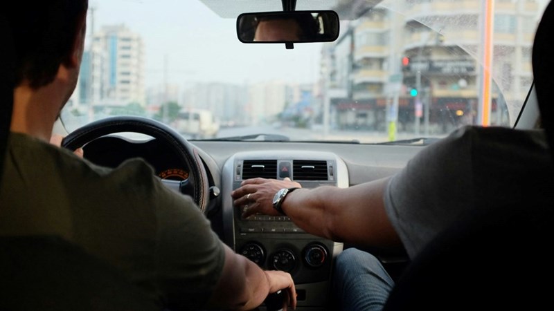 A person learning how to drive a car with someone else's assistance. Image shown for illustrative purposes; person depicted is a model.