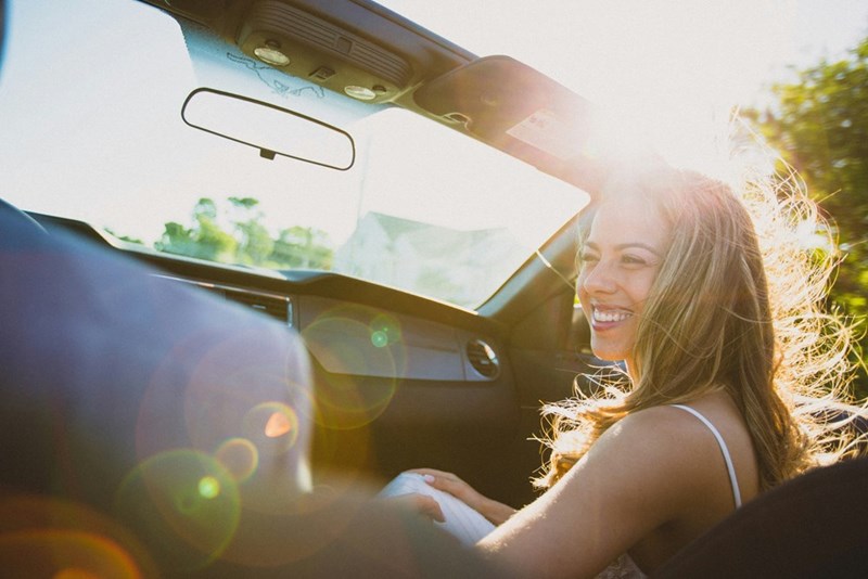 A woman enjoying a car ride. Featured likenesses do not identify those mentioned.