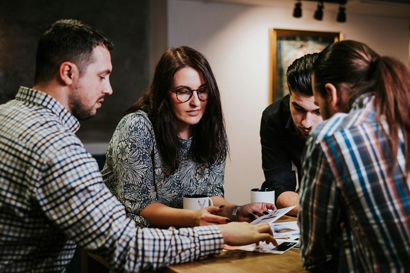 A group of people review documents in their workspace