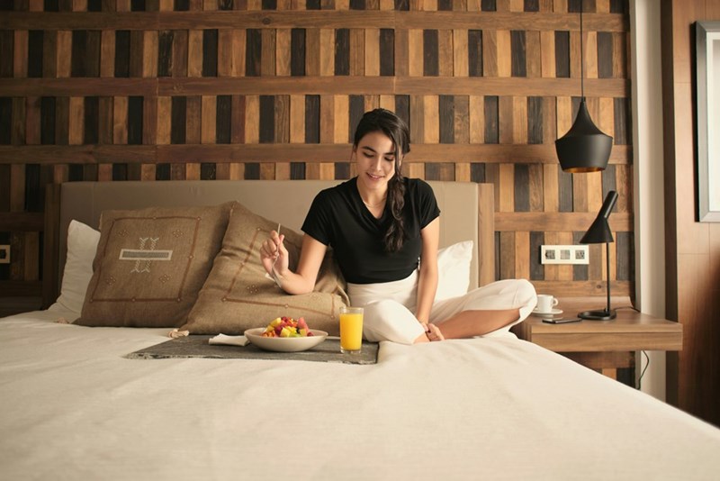 A hotel guest enjoying her breakfast in her suite. Model image.