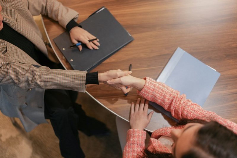 Job candidate shaking hands with CEO after receiving a second chance to prove themselves.