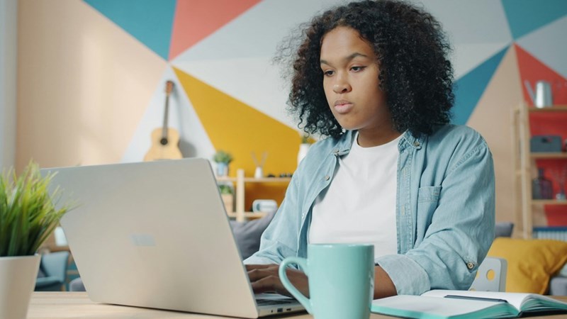 Los Angeles employee working on a laptop after being fired and discovering that her commissions and bonuses may not be included in her final pay.