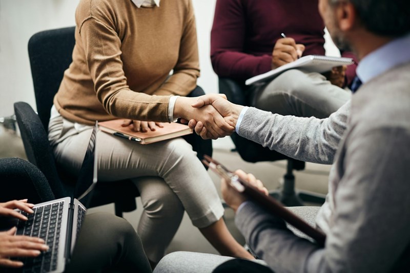 A closeup of coworkers shaking hands after a meeting in the office