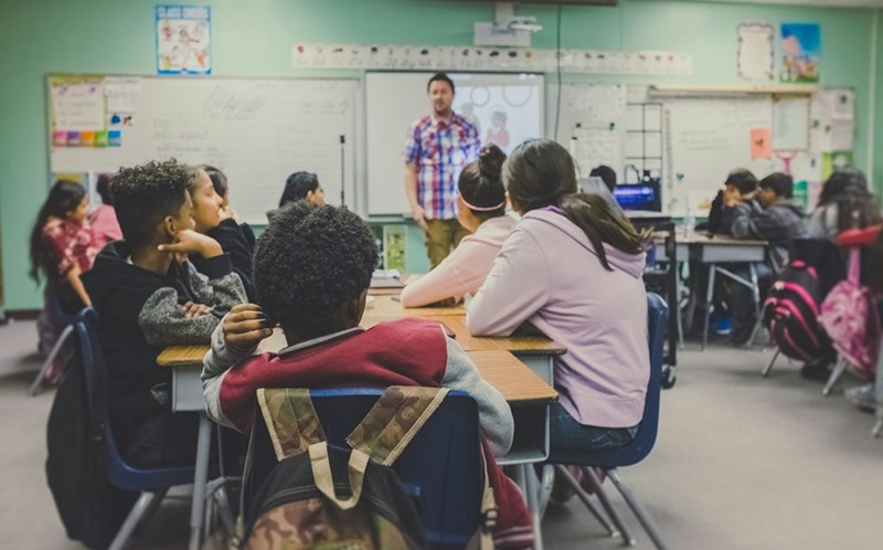 A group of middle schoolers sit in a classroom