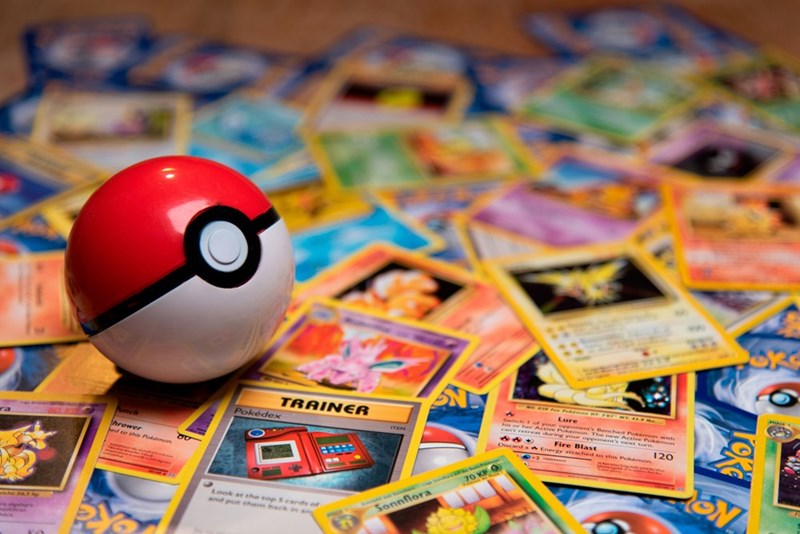 A Pokeball sitting on top of Pokémon cards.