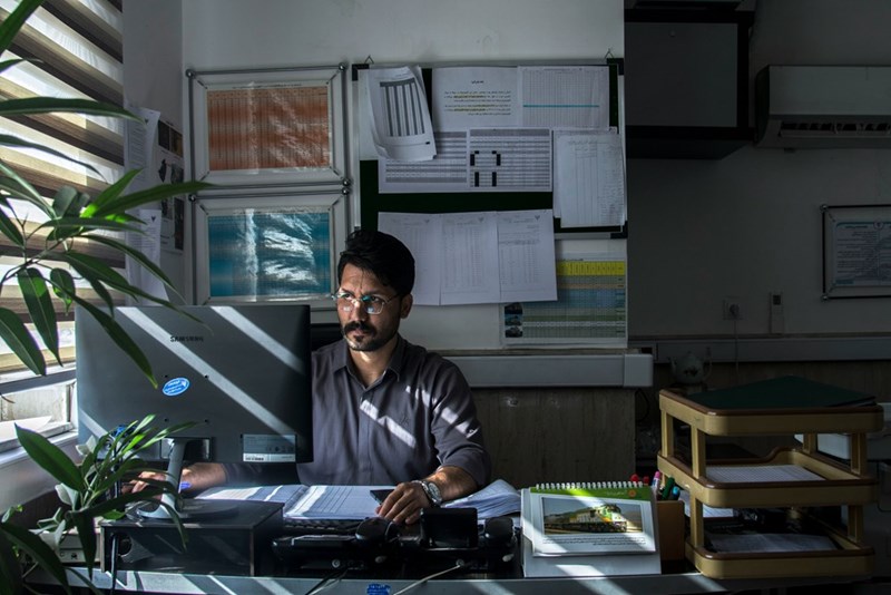 A man sits at a reception desk