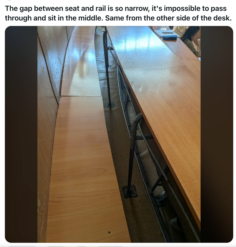 The gap between seat and rail is so narrow, it's impossible to pass through and sit in the middle. Same from the other side of the desk.