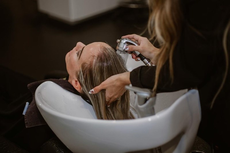 A hairstylist washing a client's hair. Representation only.