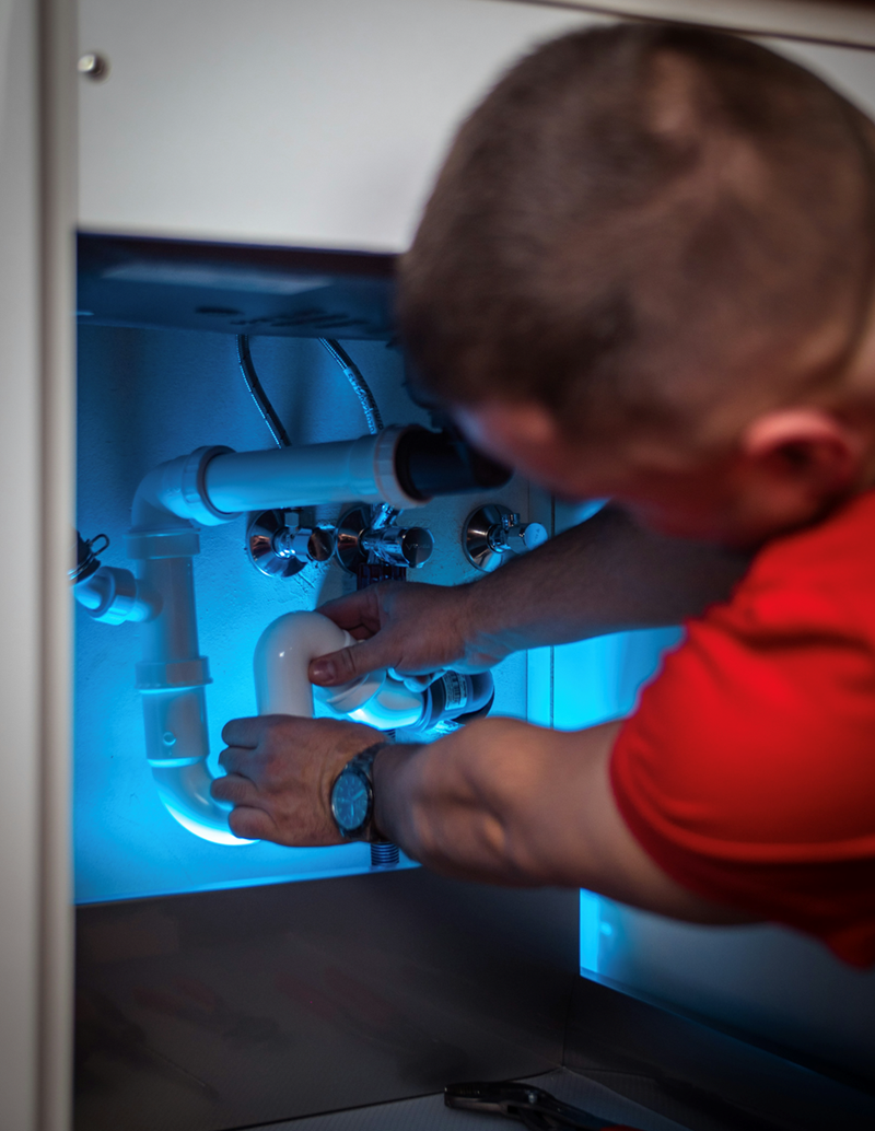 A repairman repairs an appliance.