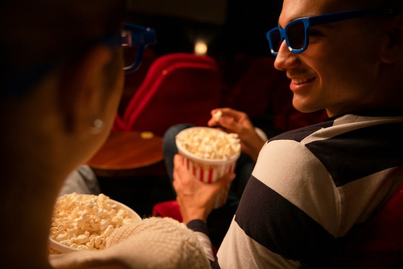 A man turns to a woman in a movie theater row