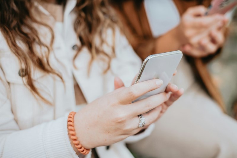 A woman holds a cell phone in her hands