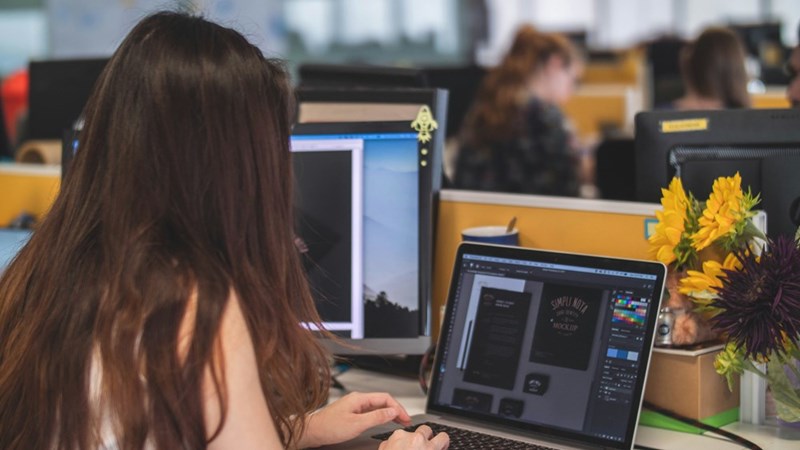 A woman sits in front of her computer at her desk