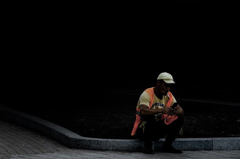 A worker in a hi vis vest takes a moment's rest to collect himself.