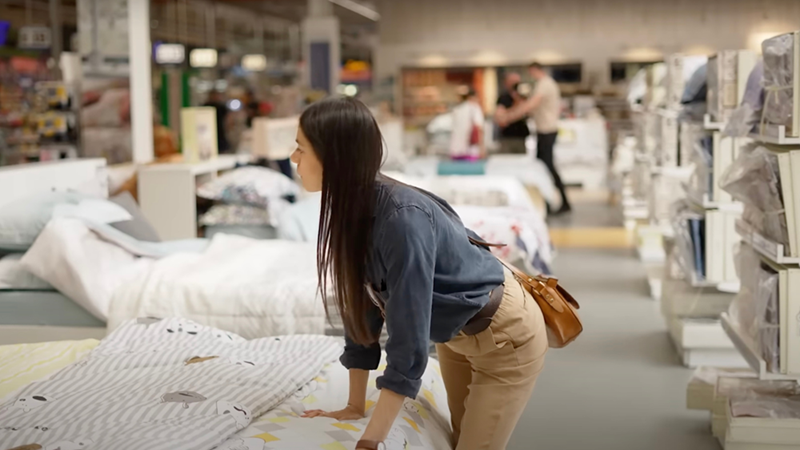 Woman testing a mattress at a store.
