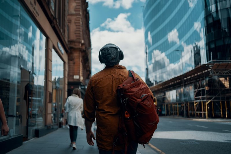 A man leaves the office and walks down the street during his commute