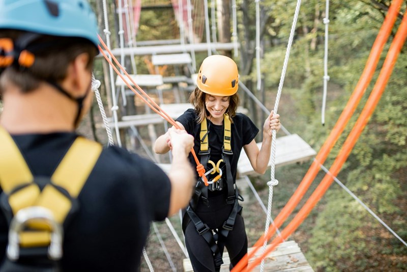 Employees are participating in a mandatory team-building ropes course on a Saturday.