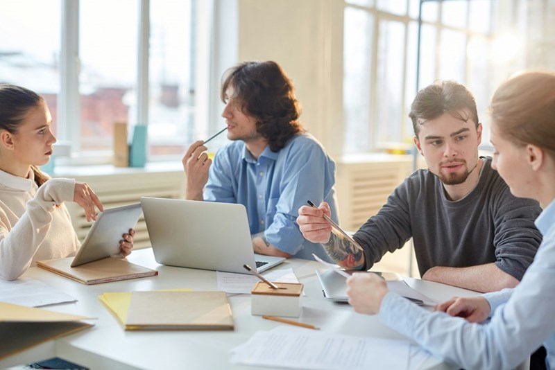 A group of businessmen sit around a table at work