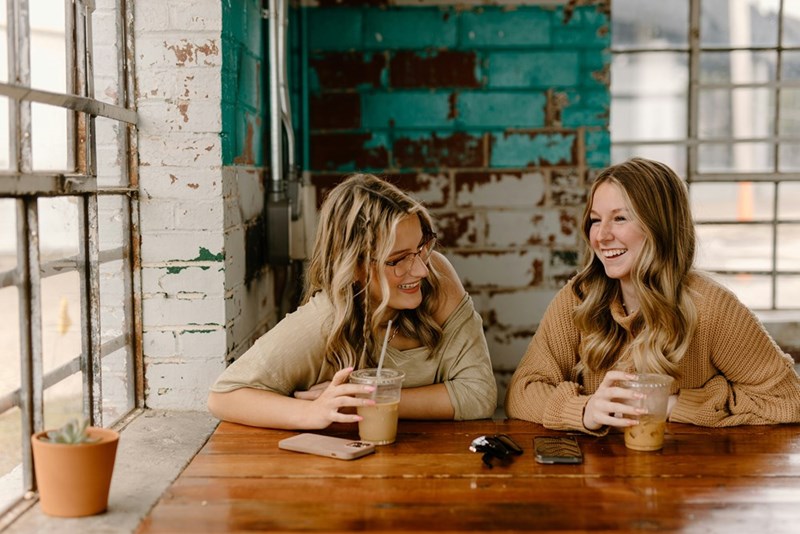 Two friends share a coffee together at a cafe