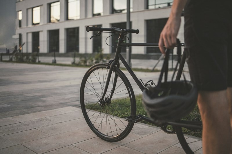 A biker with his bike in the street. Models pictured are not representative.