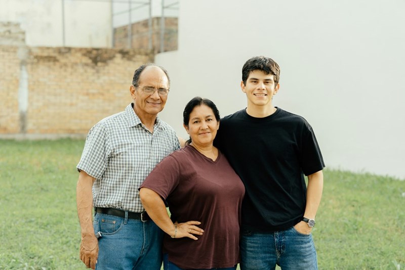 A family of three poses for a photo