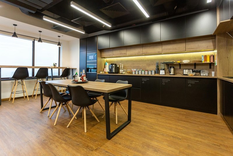 An office kitchen with a wooden table.