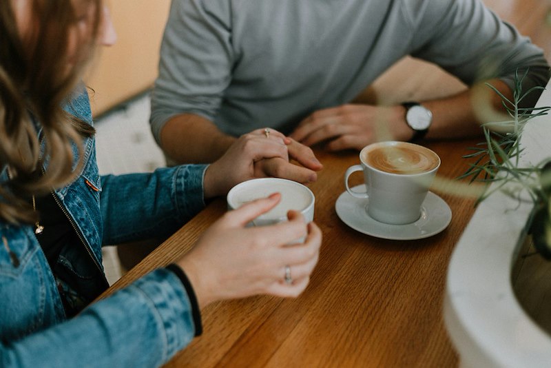 A woman and a man on a coffee date at a café. Scene is illustrative and does not depict actual individuals or events.
