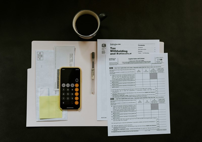 A calculator and bills on a desk.