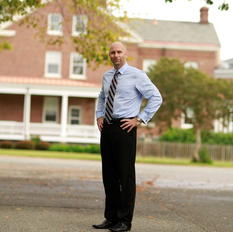 The boss stands with his hands on his hips.