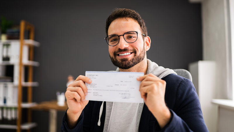 Employee happily holding their paycheck.