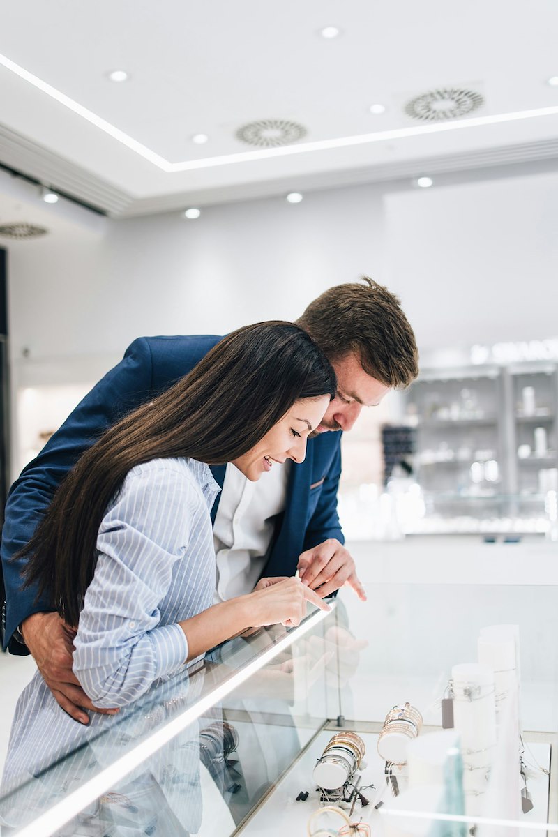 Beautiful couple enjoying shopping at modern jewelry store