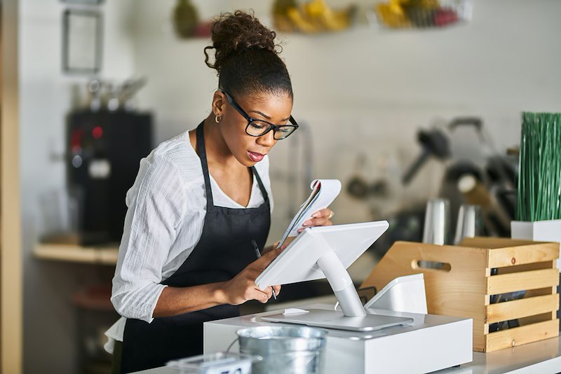 A woman punches in on a pos system at work