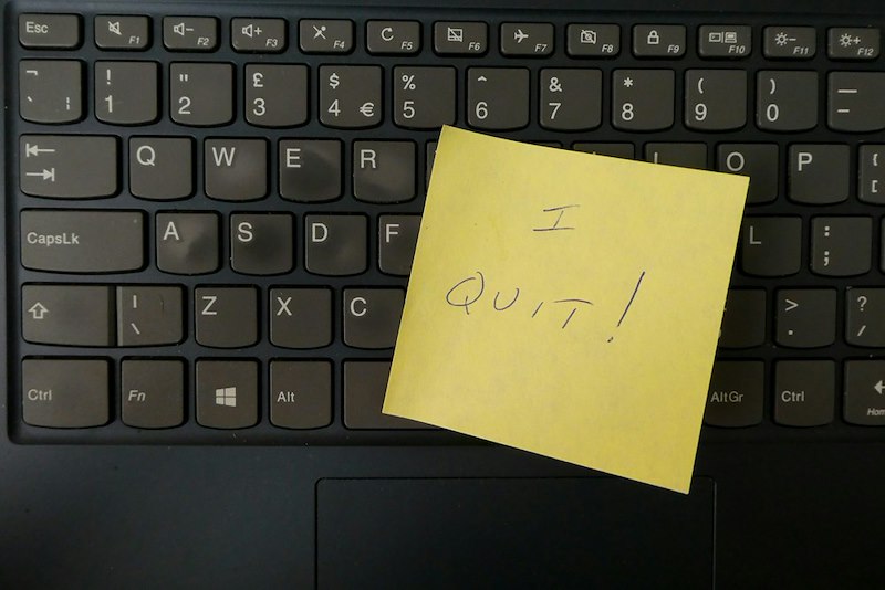A sticky note that reads “I quit” on a black keyboard