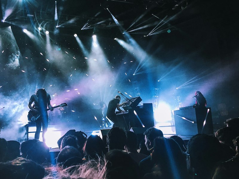 Live band performing on stage, representing the concert experience a fan paid extra to enjoy from a better seat.