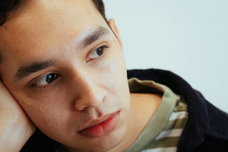 Close-up of a young man with dark hair looking away