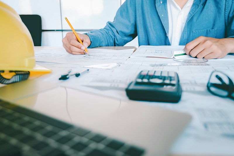 An employee works through important calculations and paperwork.