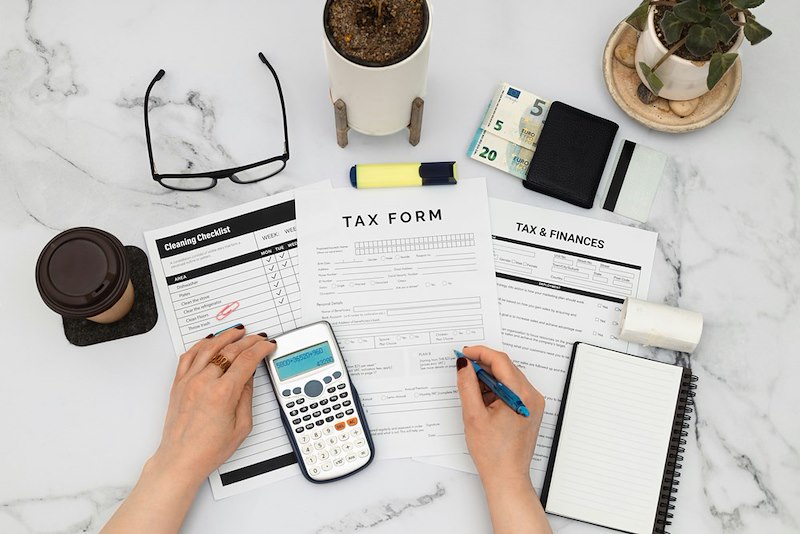A payroll employee handles financial forms and calculations.