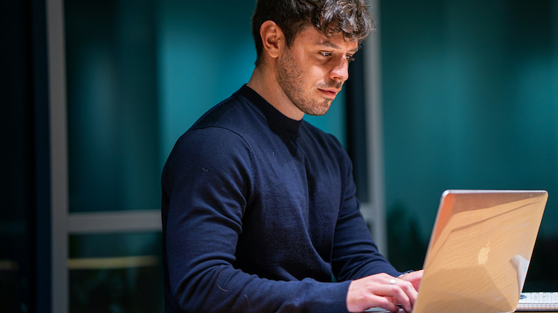 An employee works on his laptop in the evening.
