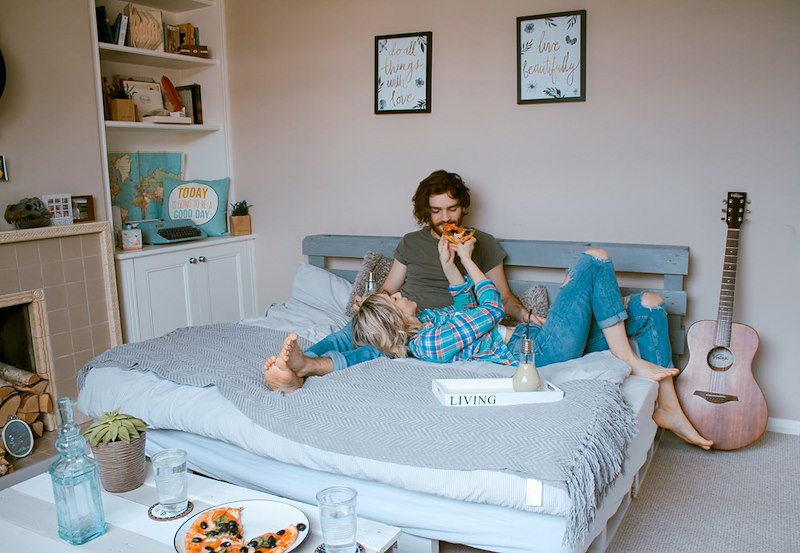 A married couple lying on a bed. Image shown for illustrative purposes; person depicted is a model.