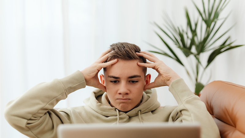 Young man holding his head in frustration.