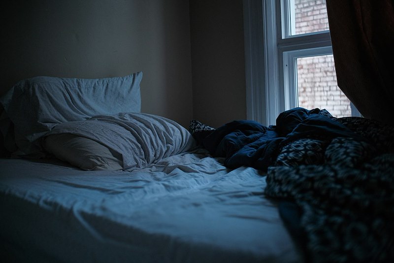 An untidy bedroom with the bed unmade.