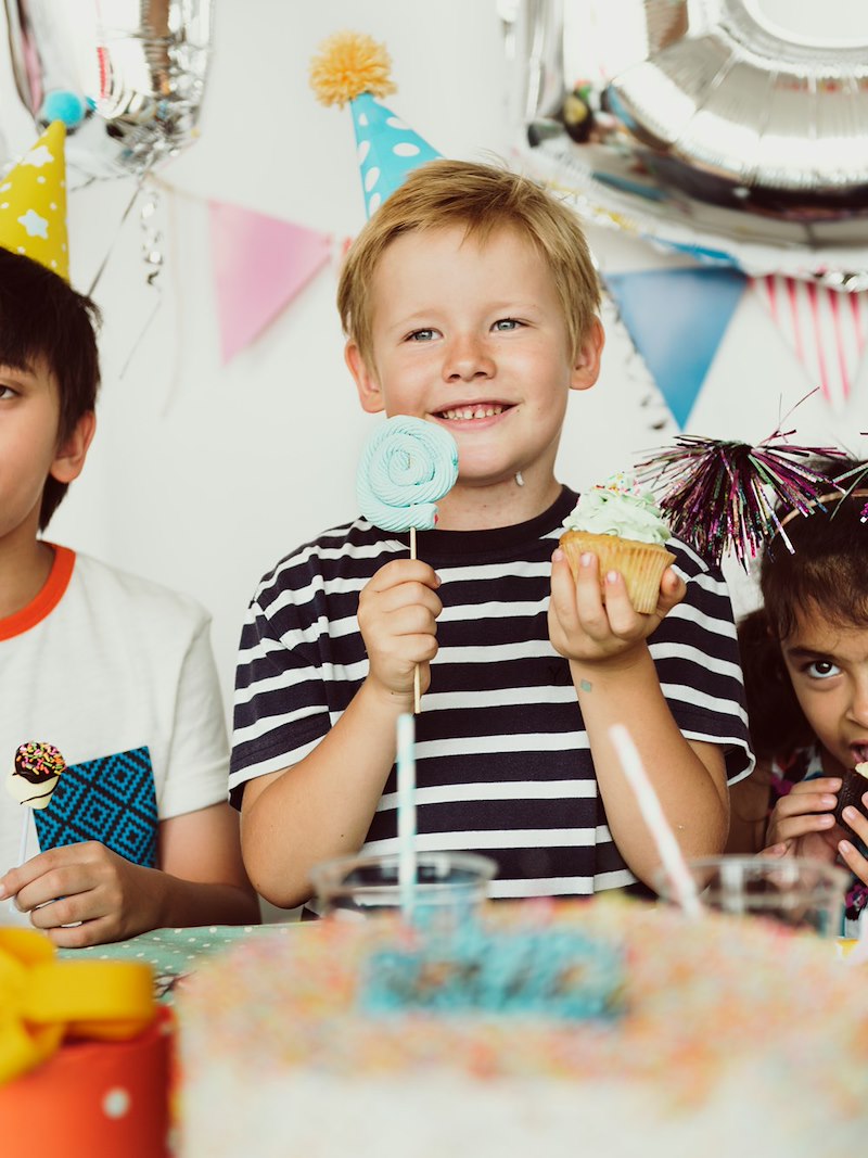 A boy enjoys his birthday treats with his friends, despite his grandmother not being there for the cake.