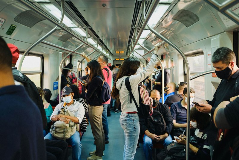 Crowded train filled with seated and standing passengers.