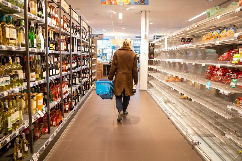 A shopper walks through a store aisle.