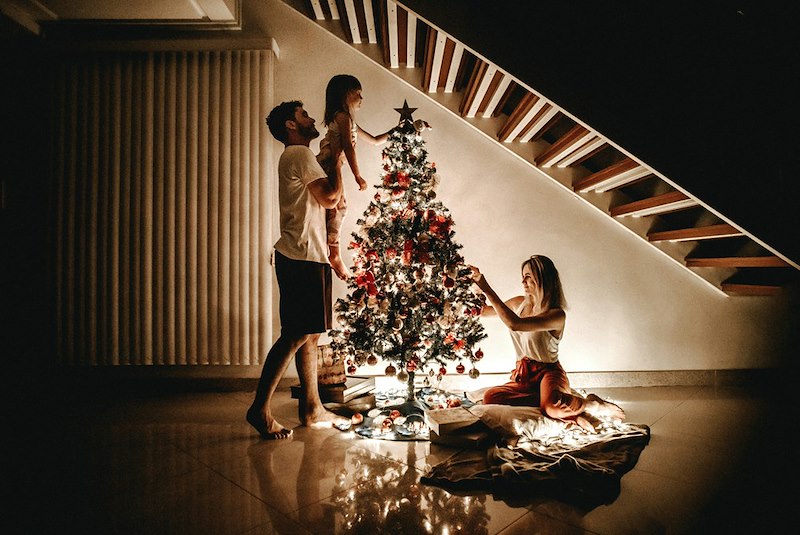 A family putting together the decorations on the Christmas tree. Models for explanatory purposes only.