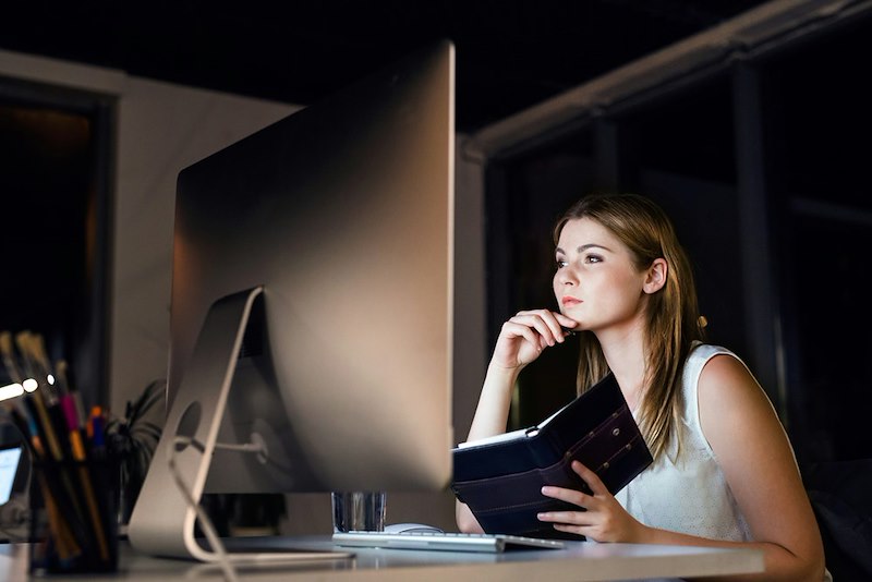 Beautiful young businesswoman in the office at night working late