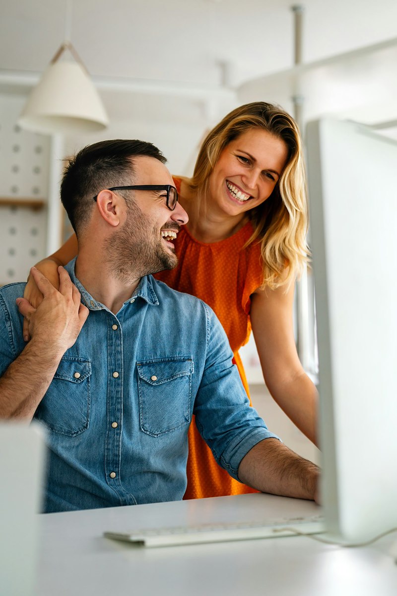 Happy couple doing business together working at a small office