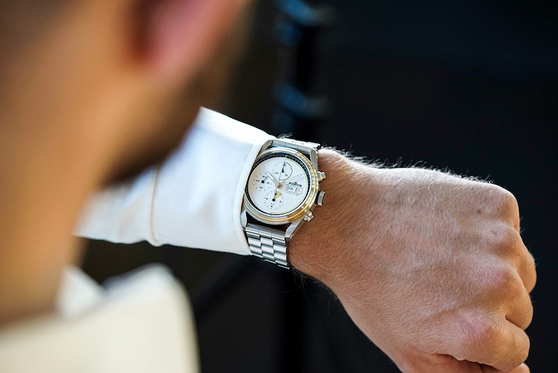 A manager checks his watch, waiting for employees to clock out.