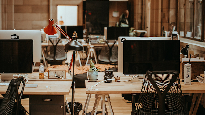 Empty desks with computers in an open-plan office.