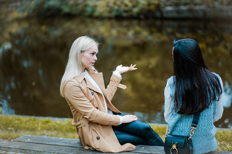 Two women have a conversation in the park