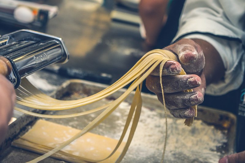 A person cooking pasta dough. Model portrayal.